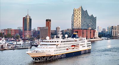 Ein kleines Kreuzfahrtschiff passiert die Hamburger Elbphilharmonie.