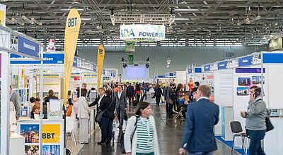 Blick in eine Messehalle mit vielen Menschen