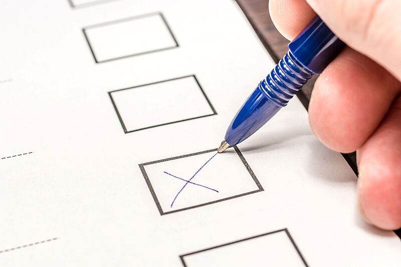 Am 10. Oktober wird ein neuer DRV-Vorstand gewählt Ein weißes Blatt Papier mit Wahlkästchen. Eine Hand hält einen blauen Kugelschreiber und markiert ein Kästchen mit einem Kreuz.