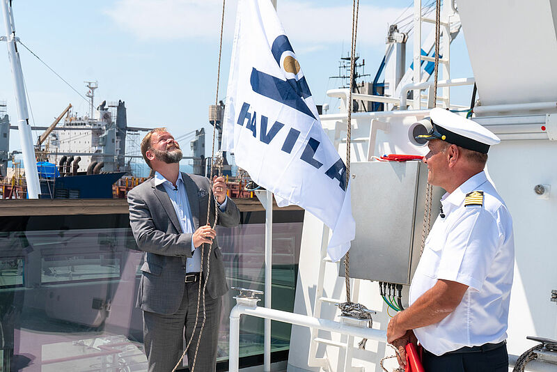 Reedereichef Bent Martini hisst die Flagge an Bord der Havila Polaris, unter den Augen von Kapitän Kurt Harald Naerbo. Foto: Martin Giskegjerde/Oclin