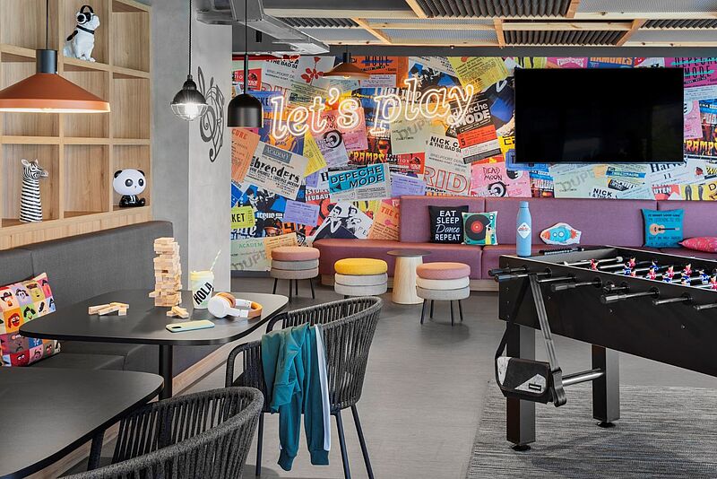Vielfarbiger öffentlicher Bereich im neuen Moxy Barcelona, man sieht einen Fußballkicker