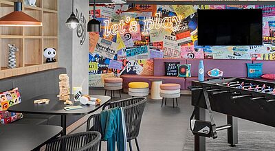 Vielfarbiger öffentlicher Bereich im neuen Moxy Barcelona, man sieht einen Fußballkicker