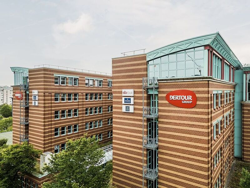 Modernes Bürogebäude der DER Touristik Group in Frankfurt, rote Backsteinoptik mit Glaselementen und Logo.