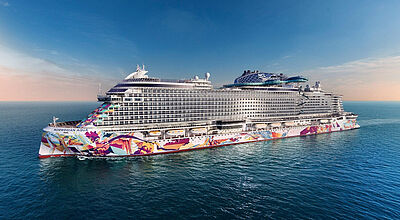 Die neue Norwegian Aqua bietet bei Doppelbelegung Platz für rund 3.500 Gäste Kreuzfahrtschiff Norwegian Aqua auf offener See mit markanter bunter Kunstbemalung am Rumpf, mehreren Decks und modernem Design