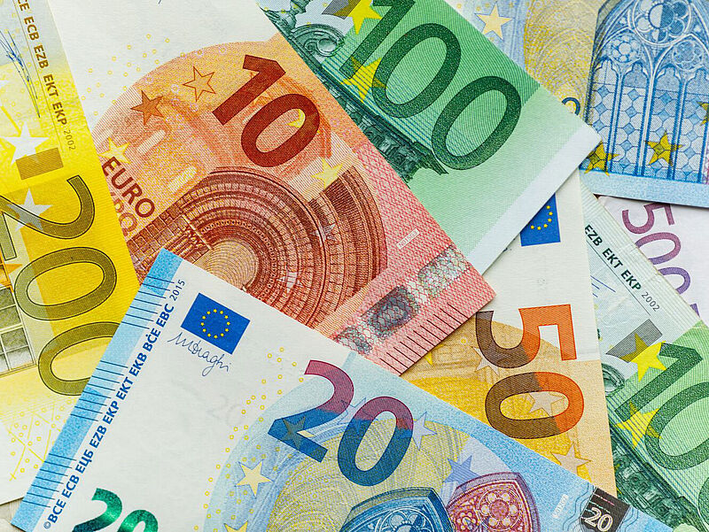 Die Gelder der Überbrückungshilfen haben viele Touristikunternehmen während Corona gerettet. Einigen drohen nun drohen allerdings hohe Rückforderungen. Foto: Vaksmanv/istock Ausgebreitete Euro-Geldscheine