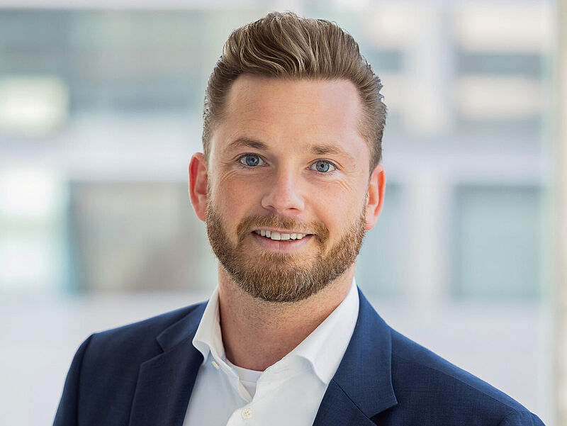 Hubert Strasser, ehemals Dertour, ist nun bei Viva Cruises. Foto: Viva Cruises Ein Mann mittleren Alters mit braunen hochstehenden Haaren und Vollbart schaut lächelnd in die Kamera. Er trägt ein Business-Outfit aus blauem Sakko und weißem Oberhemd.