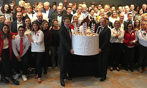 Eine Torte zum 40.: Geschäftsführer Aquilin Schömig (links) und Andreas Neumann mit Teilnehmern der Tagung im Marriott The Hague