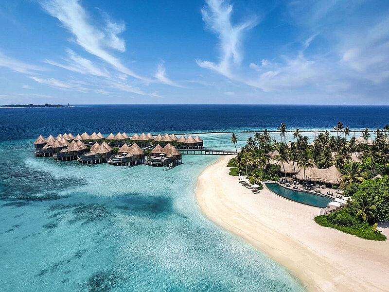 Hotelanlage Sandstrand Overwater-Bungalows Meer Malediven Palmen blauer Himmel