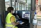 Eine Flughafen-Mitarbeiterin überwacht die Körpertemperatur der Ankommenden, die per Infrarot-Messgerät erfasst wird