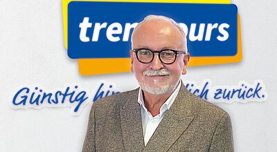 Trentours-Logo mit Slogan "Günstig hin. Sicher zurück." Davor lächelnder älterer Herr mit Brille und Bart in grauem Anzug.