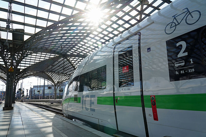 Ein ICE der Deutschen Bahn steht im Kölner Hauptbahnhof, Sonne scheint durch das gläserne Dach