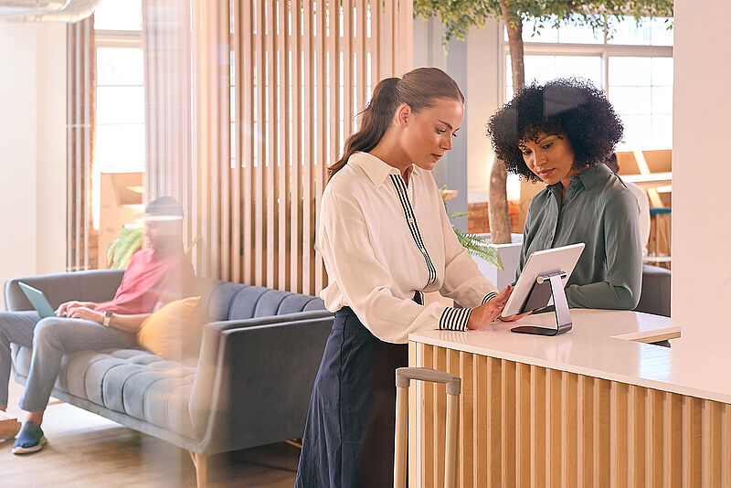 Frauen und ein Mann beim Blick auf Tablet-PCs