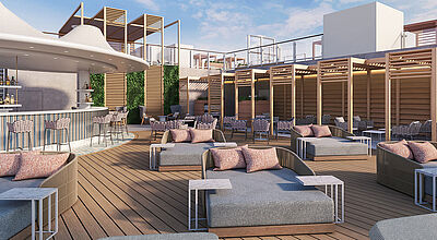 Luxuriöse Rooftop-Bar mit Lounge-Bereich auf einem modernen Kreuzfahrtschiff. Die Decks muten aus Holz gefertigt an, darauf stehen Sonnenliegen und -schirme. Der Himmel ist blau.