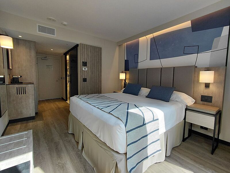 Mit dem Riu Plaza Toronto eröffnet die Kette ihr erstes Hotel in Kanada Modernes Hotelzimmer im Riu Plaza Toronto mit King-Size-Bett, stilvoller Wanddekoration, Nachttischen und stimmungsvoller Beleuchtung