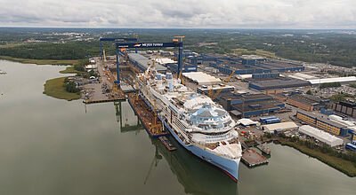 Luftaufnahme der Schiffswerft Meyer Turku in Finnland mit dem noch nicht ganz fertiggestellten Kreuzfahrtschiff Legend of the Seas.