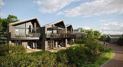 Die ersten der neuen VIP-Ferienhäuser im Center Parcs Park Eifel stehen ab Juli zur Verfügung Moderne Ferienhäuser mit großen Glasfronten und spitzen Giebeldächern in Holzoptik, eingebettet in grüne Natur mit Gehweg und Menschen unter blauem Himmel mit lockerer Bewölkung.