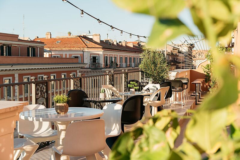 Zum Ruby Giulia in Rom gehört auch eine Dachterrasse Stylische Rooftop-Terrasse im Ruby Giulia Hotel in Rom mit modernen Sitzmöbeln, Pflanzen und Blick auf historische Häuserfassaden – perfekter Ort für Städtereisen in Italien.
