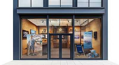 Reisebüro-Schaufenster mit Robbie-Williams-Aufsteller und Liegestuhl