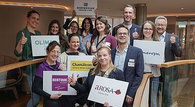 Gruppenfoto von Touristikern mit Firmenschildern auf einem Flusskreuzfahrtschiff