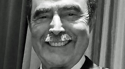 Wolfgang Fäth, Gründer des Familienunternehmens Nees-Reisen, ist im Alter von 76 Jahren verstorben Schwarz-weiß-Aufnahme eines älteren, freudig lächelnden Herren mit Anzug und Fliege, der nun verstorben ist