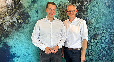 Benjamin Jacobi Stefan Baumert von TUI vor Fototapete mit Meer