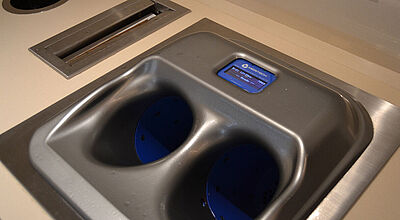 Vor dem Restaurantbereich eines Kreuzfahrtschiffs ist eine Waschbecken-ähnliche Handhygienestation eingerichtet, um Ausbrüchen von Noroviren vorzubeugen.