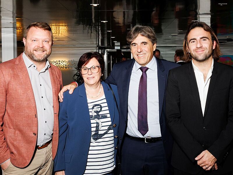 Christian Kaatz und Susi Götten (beide Anton Götten Reisen) sowie Christian Schmitter und Lucas Schmitter (Croisi Europe) bei der Feier an Bord der Lafayette. Foto: Croisi Europe/Anton Götten Reisen Gruppenbild von vier Personen auf einer Feier an Bord eines Flusskreuzfahrtschiffes.