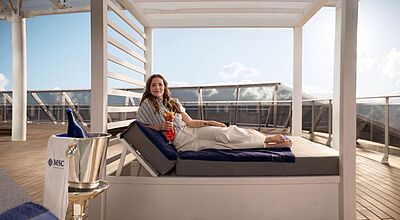 Schauspielerin Drew Barrymore wird die MSC World America taufen Eine blonde Frau auf einer Liege an Bord eines Kreuzfahrtschiffs