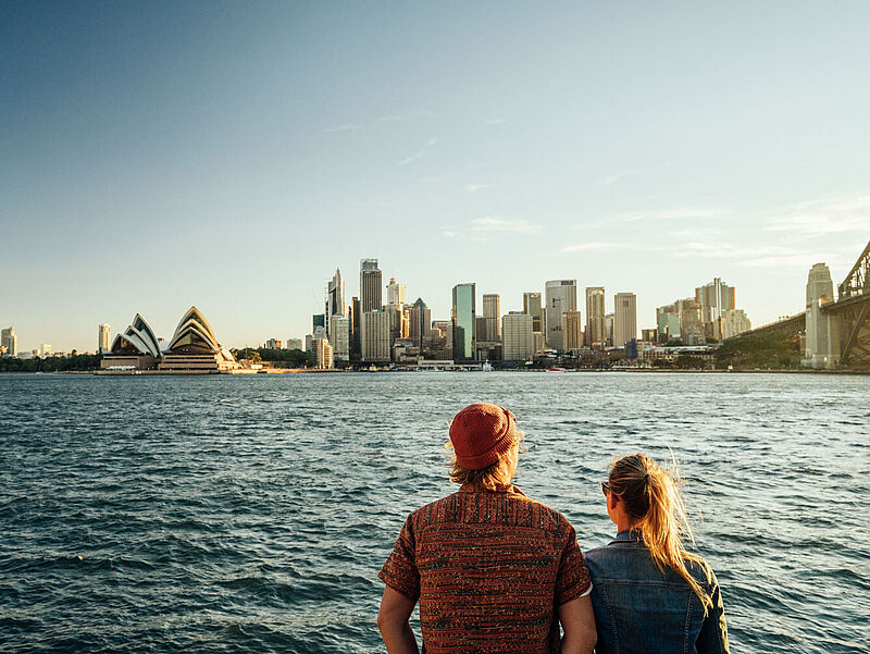 Sydney ist zu Silvester Station einer 49-tägigen Weltreise-Etappe der Aida Sol. Foto: Felix Gänsicke Ein Paar steht mit dem Rücken zur Kamera und blickt aus der Ferne auf die Skyline von Sydney.
