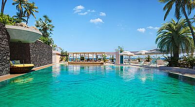 Traumhafter Pool im Iberostar Selection Fuerteventura Palace auf den Kanaren mit Palmen, Sonnenliegen und Meerblick unter blauem Himmel