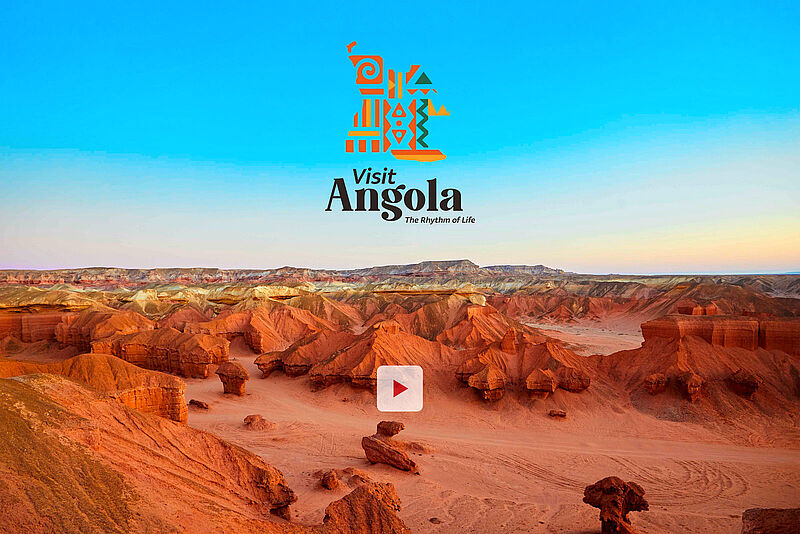 Weite Landschaft mit rotbraunen Felsformationen und tiefen Schluchten, die sich in der Wüste unter klarem, blauem Himmel erstrecken.