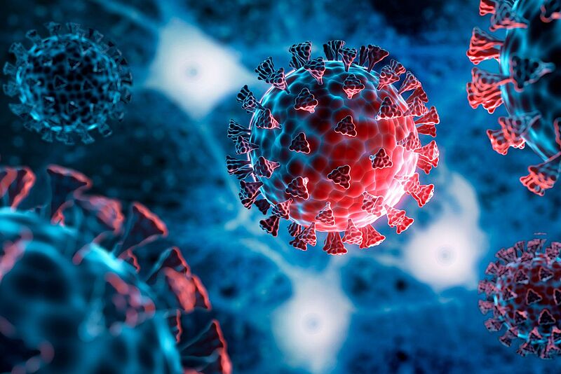 Das Symbolbild zeigt roten Virenkörper in der Nahaufnahme vor blauem Hintergrund.