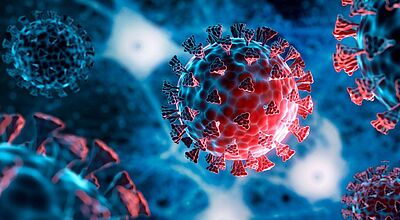 Das Symbolbild zeigt roten Virenkörper in der Nahaufnahme vor blauem Hintergrund.