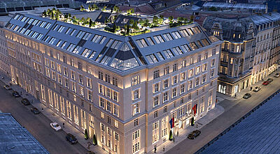 In der Dämmerung steht übers Eck ein über 100 Jahre altes Gebäude mit einer renovierten Fassade
