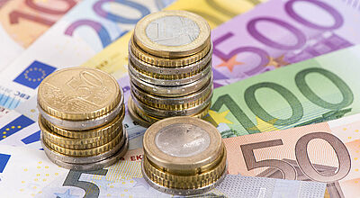 Euro-Scheine aufgefächert Euro-Münzen aufgetürmt