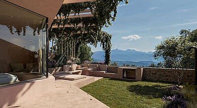 Rittstein Homes in Eppan: Terrasse mit Pergola, Naturstein und Rankpflanzen; großes Fenster mit Landschaftsblick, Slow Luxury.