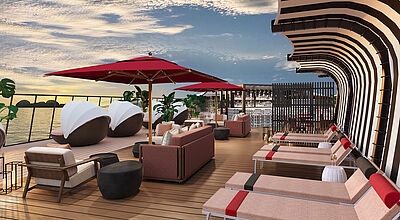 So soll das neue Sonnendeck des Suiten-Bereichs The Retreat aussehen. Modell: Celebrity Cruises Modellbild eines neugestalteten Sonnendeckbereichs auf einem Kreuzfahrtschiff. Moderne Sonnenliegen und Sofas sowie runde Cabanas mit faltbarem Dach sind zur Reling und auf das blaue Meer ausgerichtet. Rote Sonnenschirme spenden Schatten.