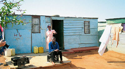 Elendsquartier in Soweto: eine Hütte aus Wellblech ohne Wasser und Strom.