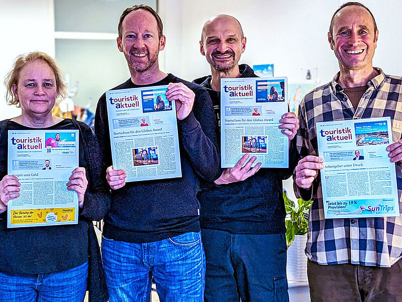 Eine Redakteurin und drei Redakteure mit Zeitschriften in Redaktion