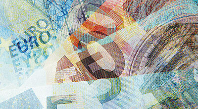 Eine farbenfrohe, künstlerische Überlagerung mehrerer Euro-Geldscheine verschiedener Stückelungen, bei der Sicherheitsmerkmale, Zahlen und architektonische Motive ineinander verschwimmen.