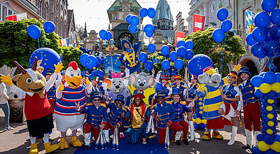 Gruppe von kostümierten Menschen und Maskottchen in einem Freizeitpark