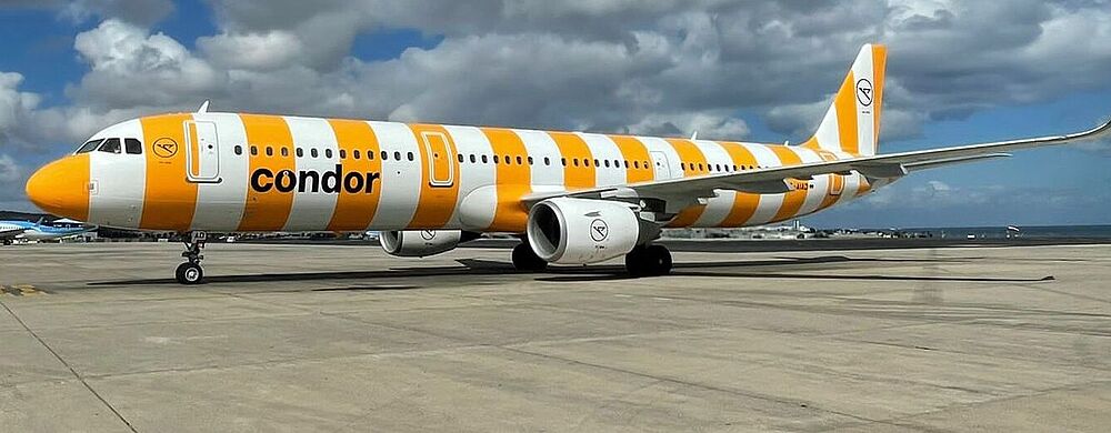 Condors Airbus-Maschinen müssen nicht am Boden bleiben- Foto: Condor Ein gelb-weiß-lackiertes Condor-Flugzeug steht am Boden.
