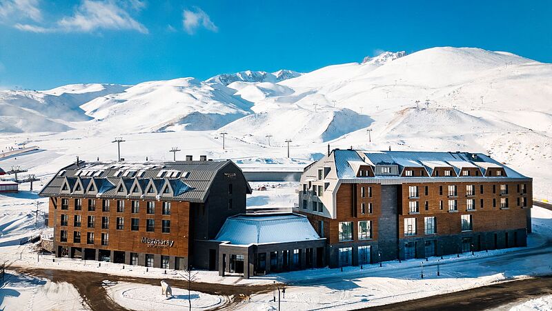 Ein Hotel in einer Winterlandschaft mit blauem Himmel