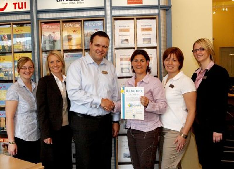 Karina Kaspari von ETI bei der Zertifikatsübergabe an Reisebüro-Chef Markus Michel.