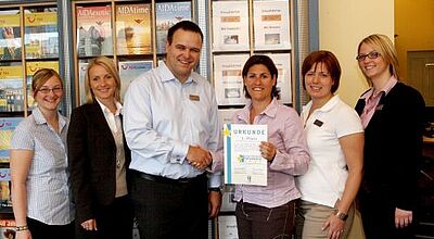 Karina Kaspari von ETI bei der Zertifikatsübergabe an Reisebüro-Chef Markus Michel.