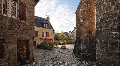 Das bretonische Pont-Croix gehört zu den „Petites Cités de Caractère“ – kleinen Städten mit besonderem Charme. Blick auf die Altstadt von Pont-Croix in der Bretagne mit dem charakteristischen Kopfsteinpflaster sowie kleinen Gassen und alten Steinhäusern.