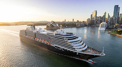 Kreuzfahrtschiff vor der Kulisse Sydneys mit Skyline und Opernhaus