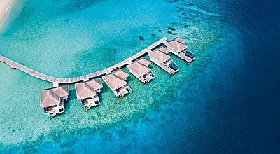 Sechs Overwater-Villen in türkisgrünem Wasser von oben