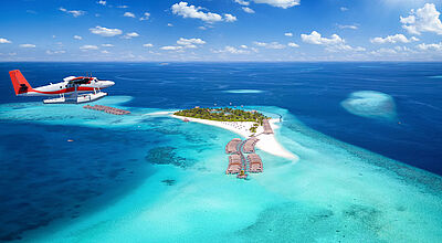 Wasserflugzeug über kleiner Malediveninsel mit Overwater-Bungalows