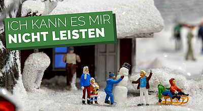 Kleine Plastikfiguren auf Kunstschnee mit Schriftzug „Ich kann es mir nicht leisten“